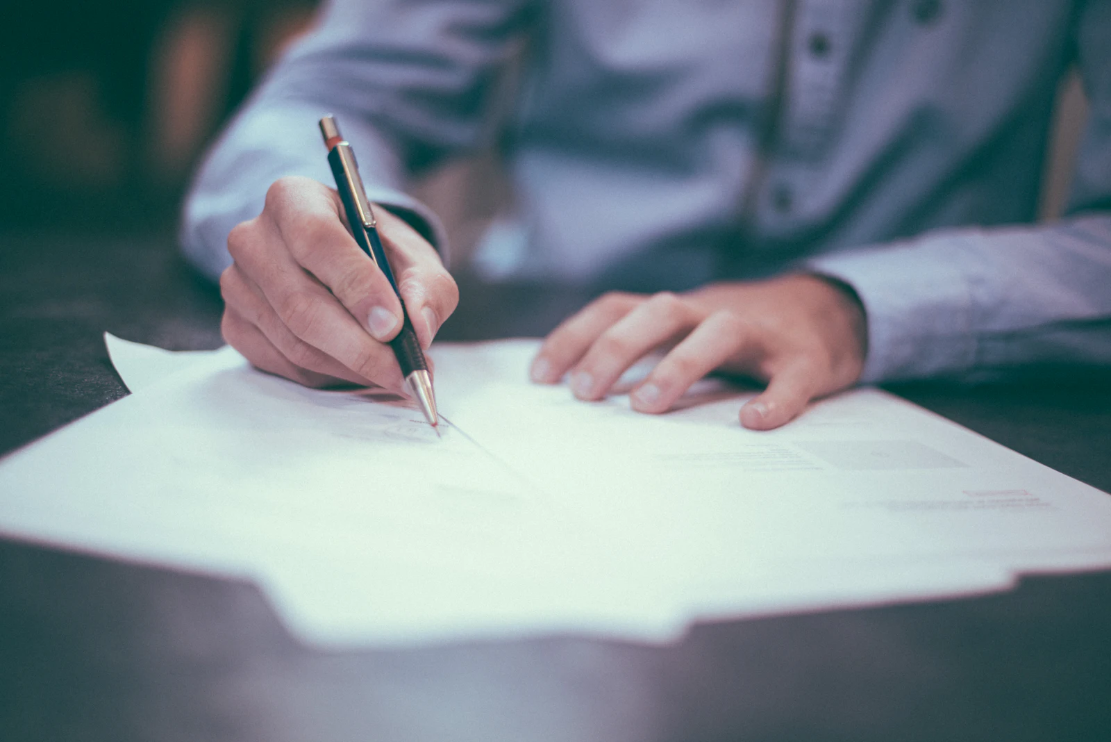 Placeholder photograph of loan documents being signed